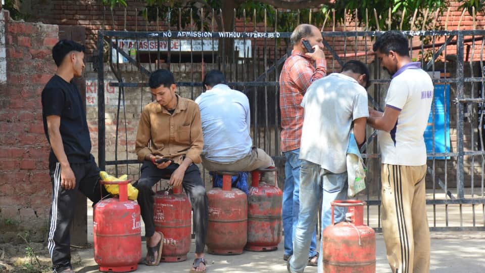 गैस सिलिंडर केलिए एजेंसी के बाहर खड़े लोग।