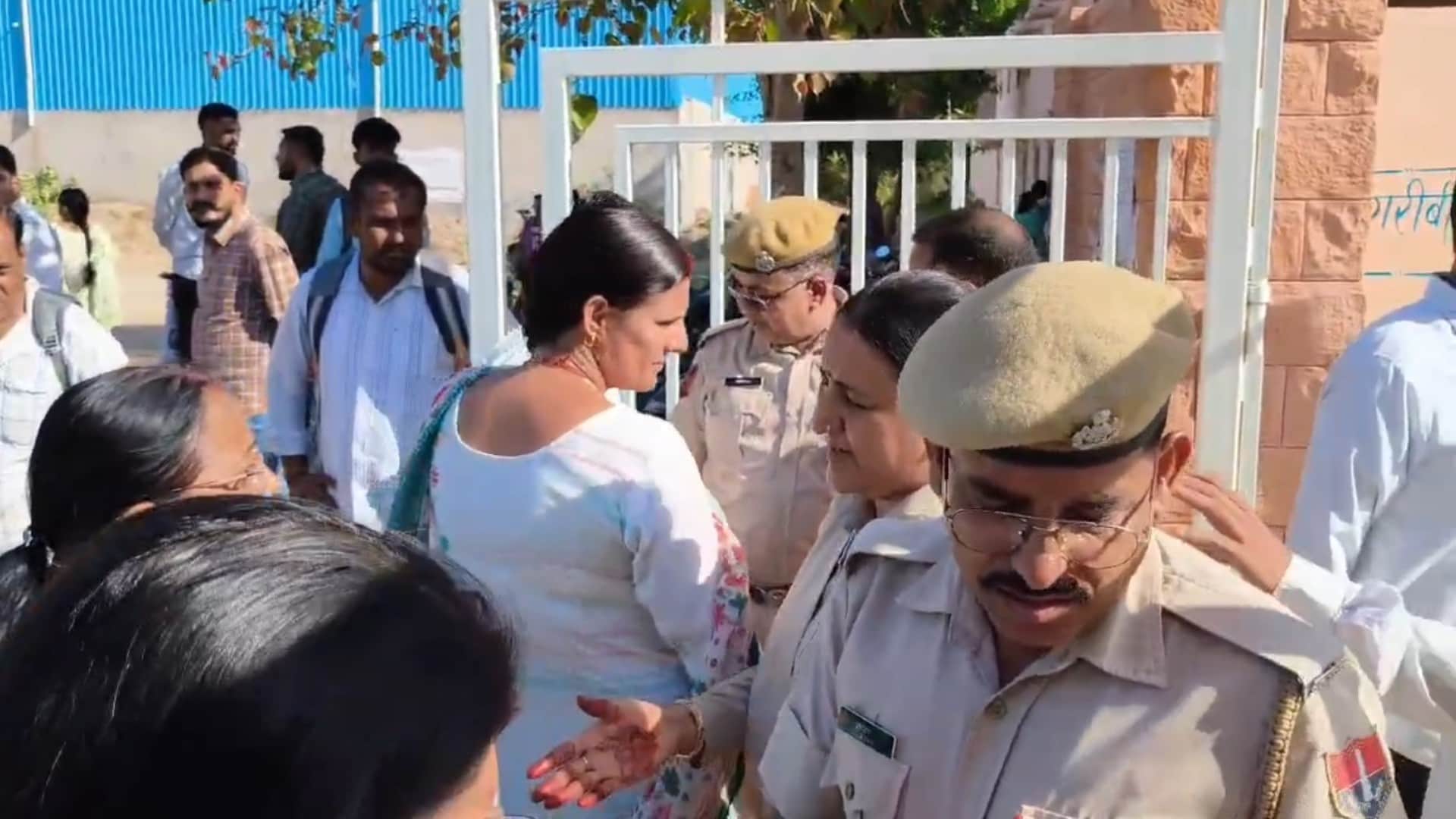 हंगामे के बाद गेट के बाहर इंतजार करते अभ्यर्थी