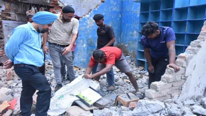 मलबे में सामान तलाशते दुकान के कर्मचारी