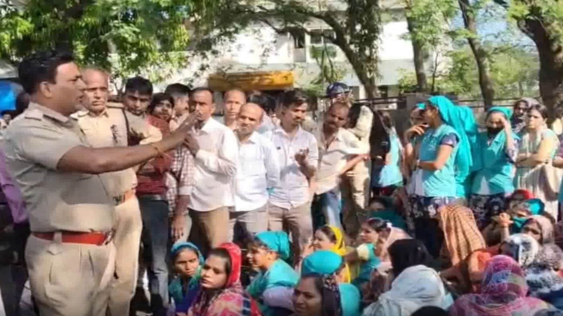 श्रमिकों के साथ समझाइश करते पुलिसकर्मी