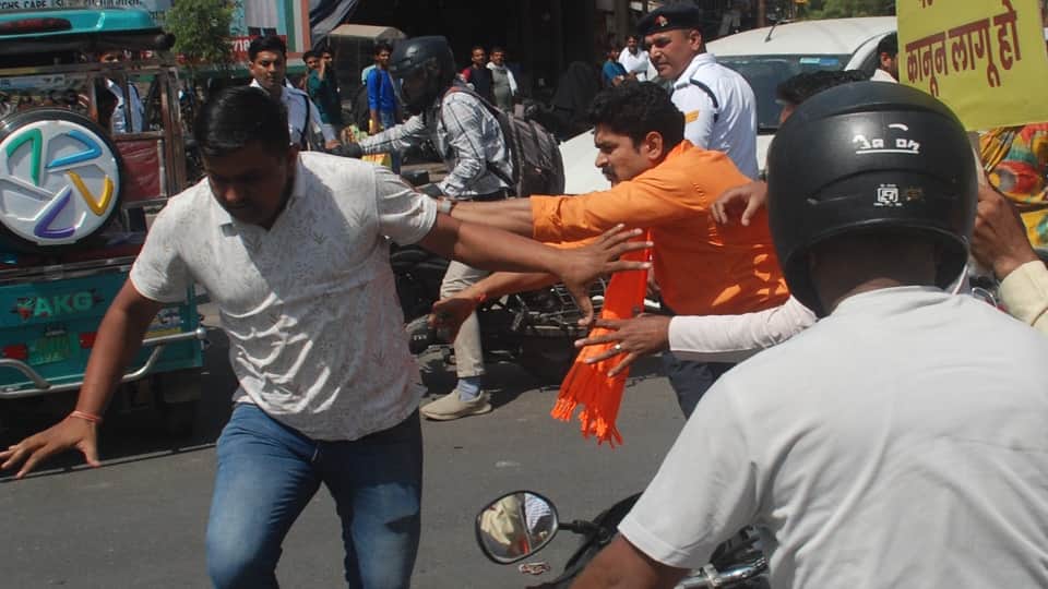 सिपाही से मारपीट करते बजरंग दल कार्यकर्ता।