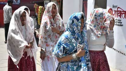 धूप से बचने के लिए चेहरा बांध कर जातीं युवतियां।