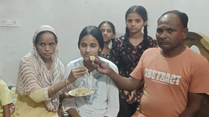 अक्षरा को मिठाई खिलाते माता-पिता