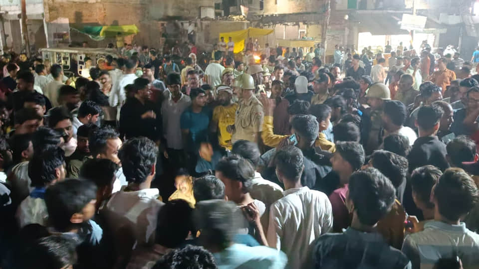चौराहे पर जाम लगाकर प्रदर्शन करते परिजन व व्यापारी