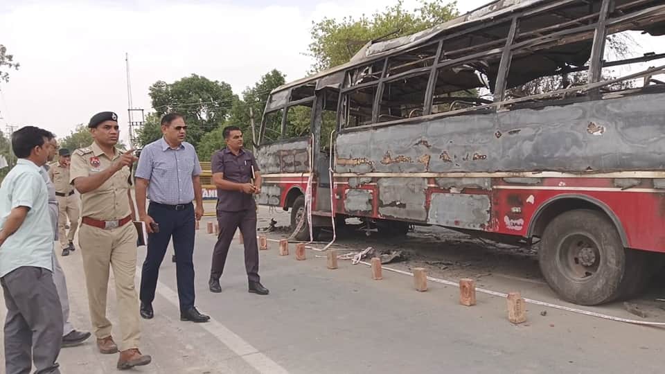 दुर्घटनाग्रस्त बस की जांच करते पुलिस अधिकारी