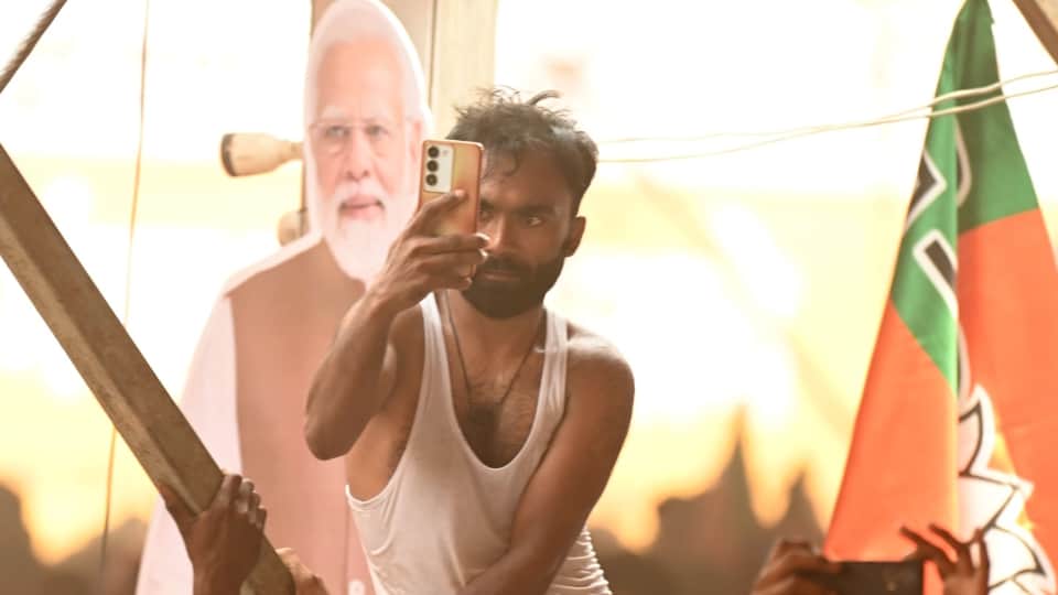 मल्लावां में गंगा एक्सप्रेस-वे के शुभारंभ पर पीएम मोदी की फोटो लेता युवक