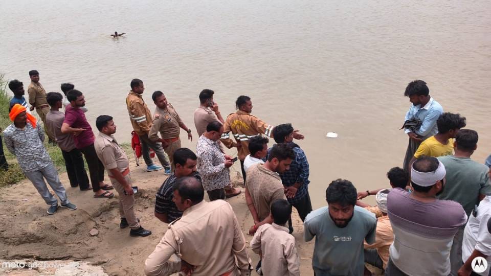 नदी किनारे मौजूद पुलिस व लोग।