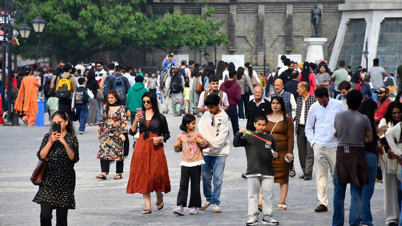 शिमला के रिज मैदान पर सुहावने मौसम में घूमते सैलानी।