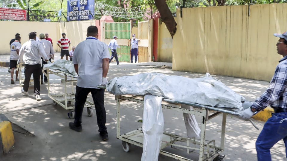 दिल्ली अग्निकांड में मारे गए लोगों के शवों को पोस्टमार्टम के लिए लेकर जाते हुए