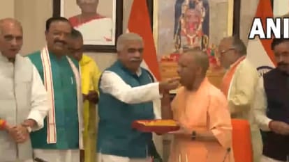 योगी ने डिप्टी सीएम को खिलाई मिठाई।