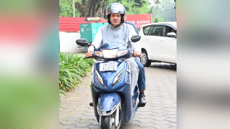 Dehradun: मंत्री ने तेल बचाने को स्कूटी चलाई, अब जुर्माने की नौबत आई; इस वजह से सोशल मीडिया पर हुए ट्रोल