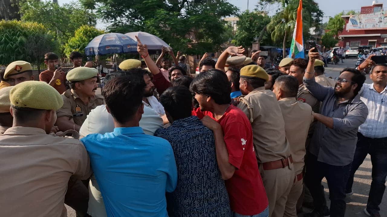 कांग्रेस कार्यकर्ताओं से पुतला छीनते पुलिसकर्मी