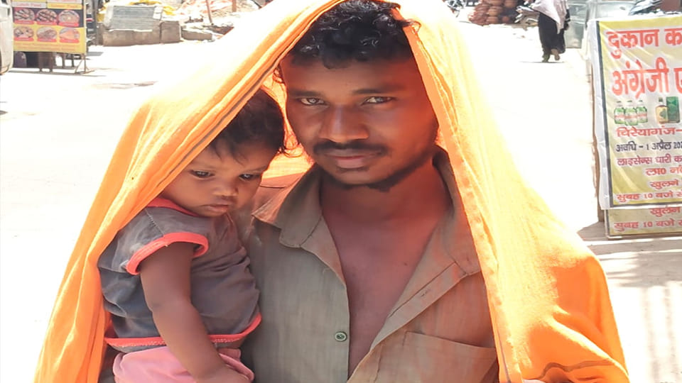 ज धूप में बच्चे और खुद को इस तरह बचाता दिखा युवक