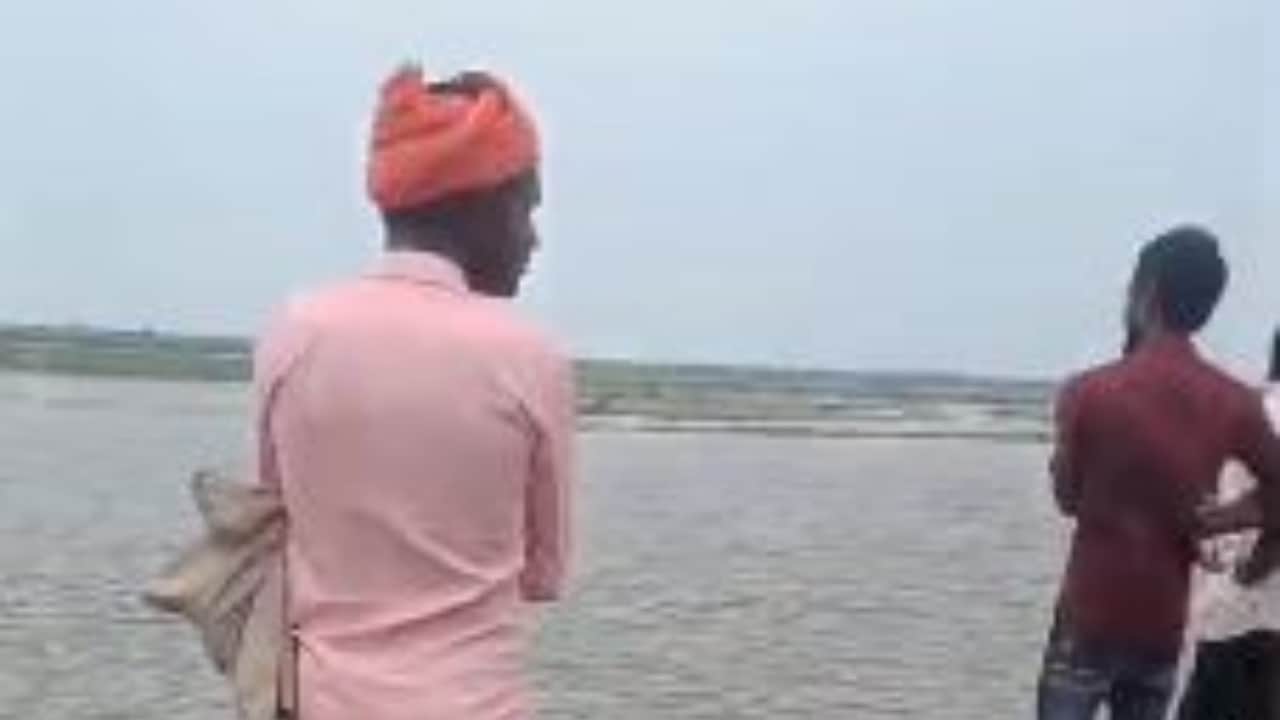 नदी किनारे खड़े ग्रामीण