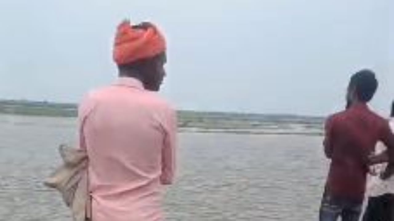 नदी किनारे खड़े ग्रामीण