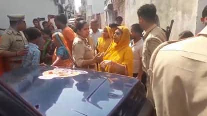 Uproar over wedding hall construction women stand in front of police vehicle in Shahjahanpur