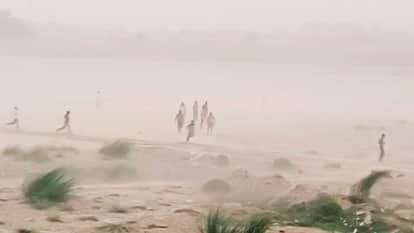 गंगा के उस पार रेती पर मस्ती करते लोग।