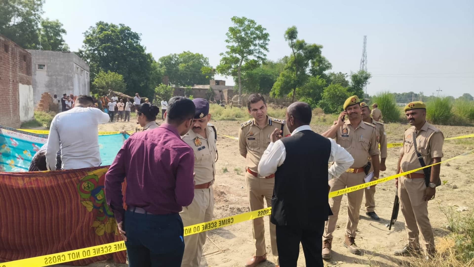 मेजा के नीबी कुकुरकटवा गांव में तिहरे हत्याकांड के बाद छानबीन करते पुलिस अधिकारी।