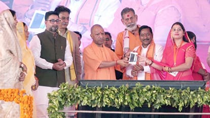 लाभार्थियों को सम्मानित करते सीएम योगी।