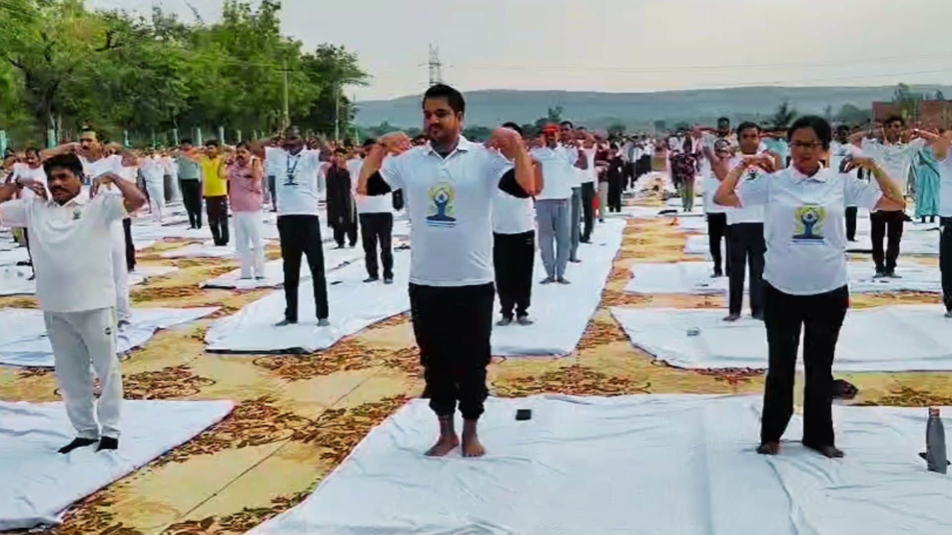 योग दिवस पर प्राणायाम करते लोग।