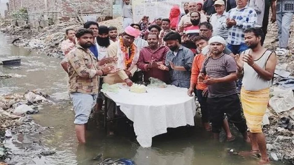 BJP councilor cuts cake after stepping into a filthy drain on his birthday.