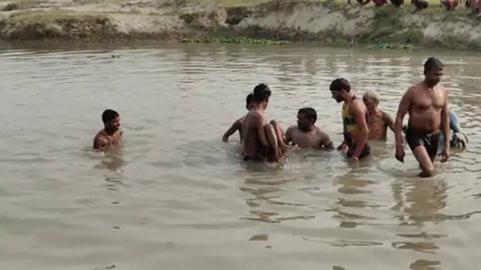 नदी में बच्चों की तलाश करते गोताखोर।