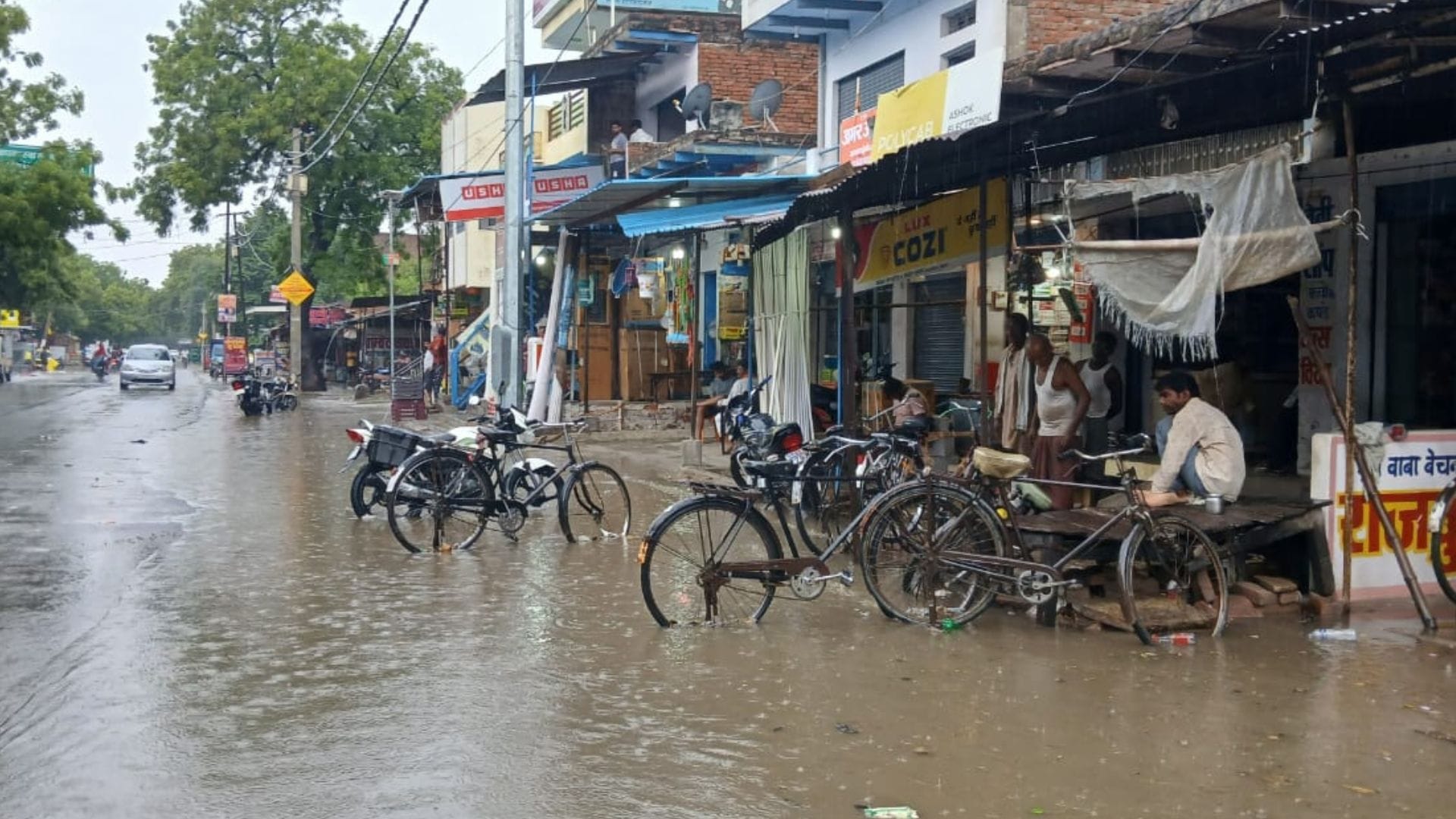 Rain from city to village in varanasi Knee-deep water people forced to drag two wheelers difficult