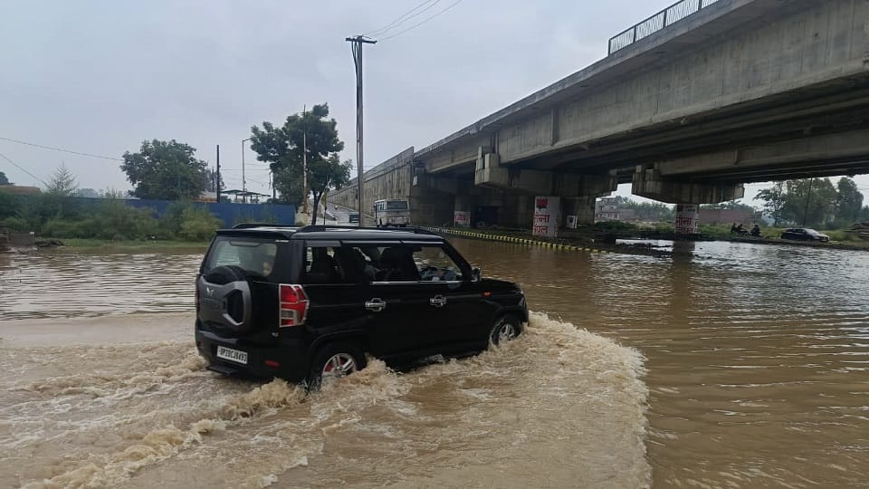 नजीबाबाद- मेरठ-पौड़ी राष्ट्रीय राजमार्ग पर जलालाबाद क्षेत्र में जलभराव से गुजरते वाहन।