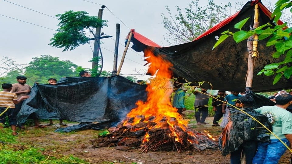 Last rites performed under tarpaulin at the crematorium