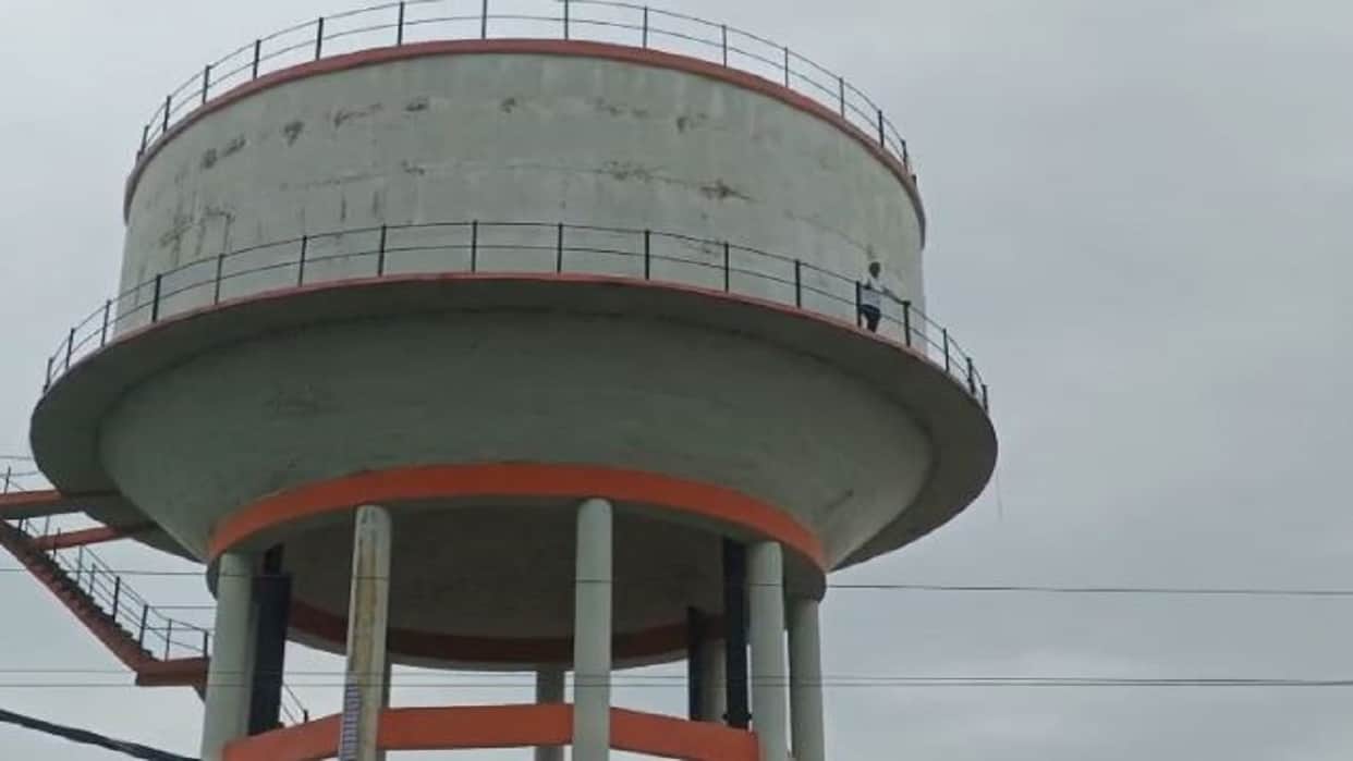 Villager climbs water tank over road construction in Pilibhit