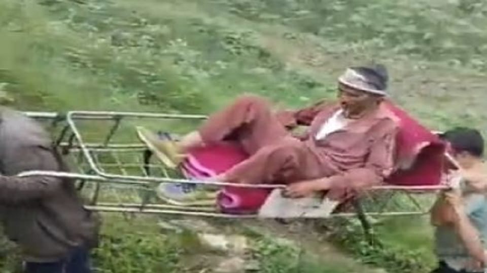 डोली पर धन सिंह को ले जाते लोग