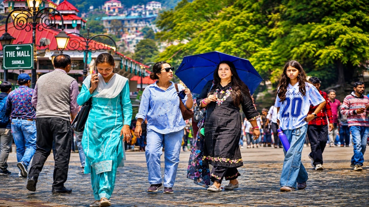 शिमला के रिज मैदान पर गुजरते लोग।