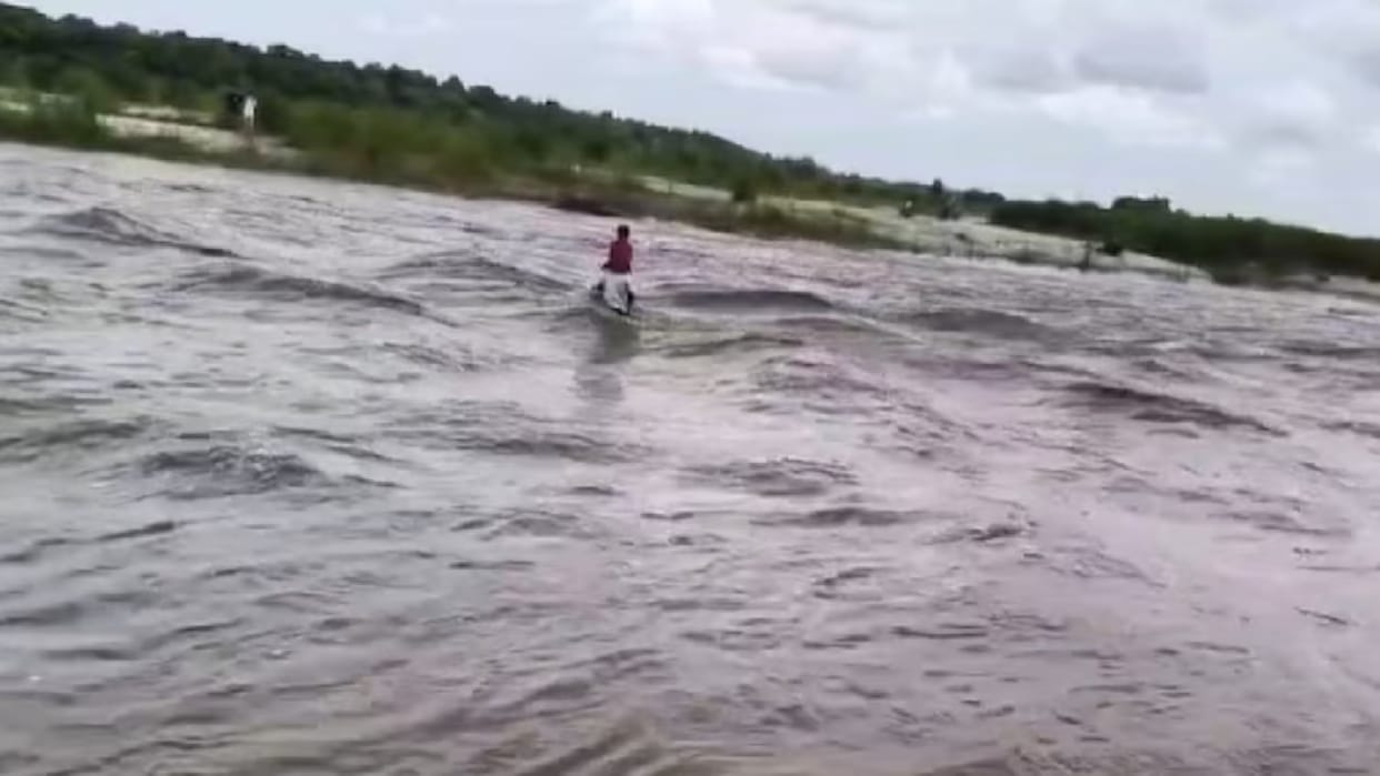 father carrying son across river on shoulder to make him reach school viral video bihar news in hindi