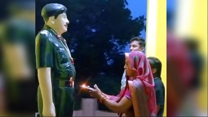 शहीद की प्रतिमा की आरती उतारते परिजन।