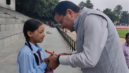 बच्ची को चॉकलेट देते सीएम धामी