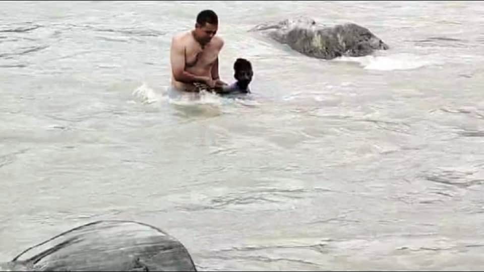 उत्तरौड़ा में नदी के बीच में फंसे युवक को रेस्क्यू करते ग्राम प्रधान।