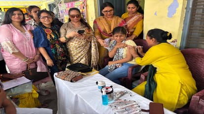 शिविर में वैक्सीन लगवाती छात्रा