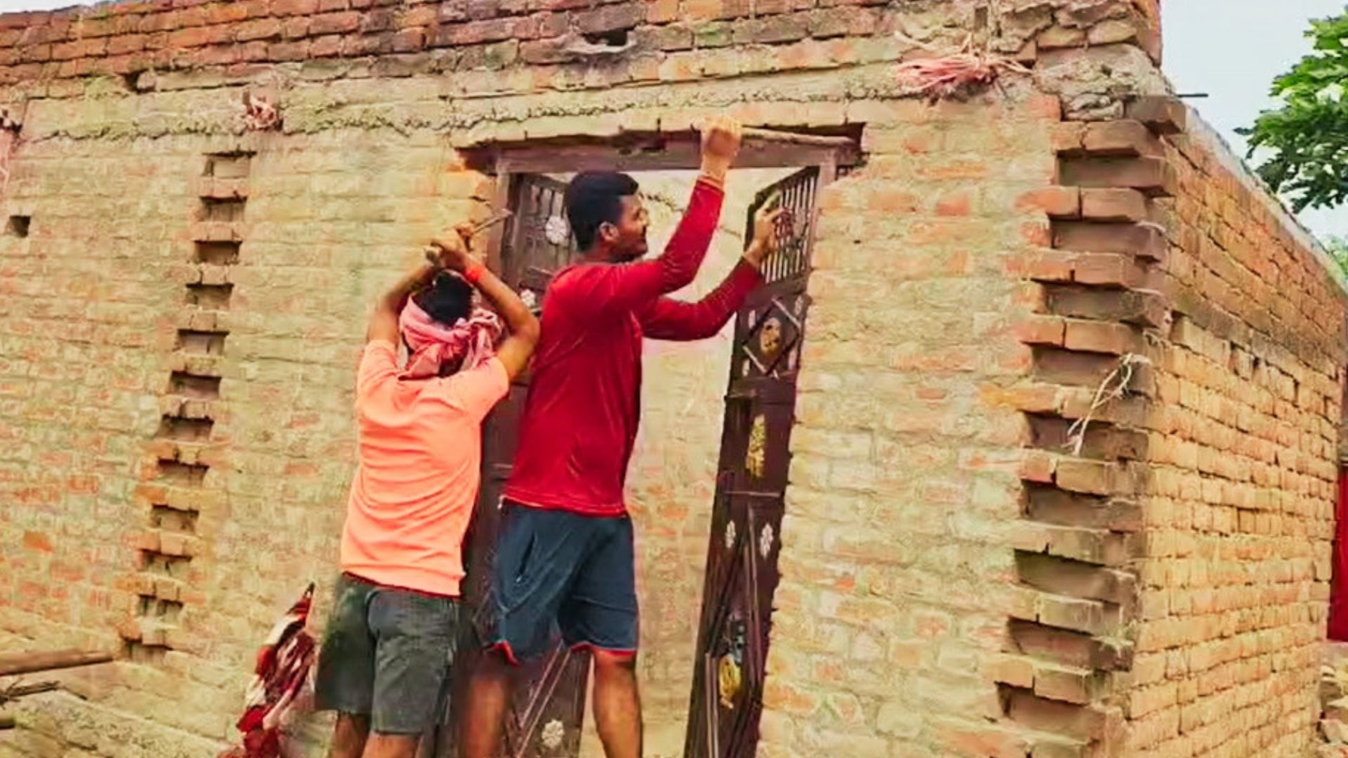मकान का दरवाजा खोलते लोग।