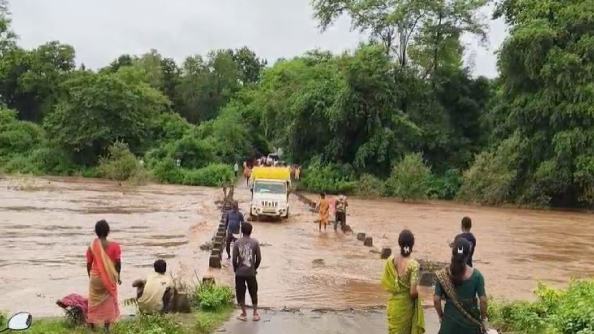 ऊफनती गेउर नदी पार करते वाहन और लोग