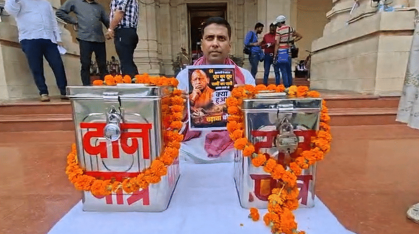 UP: SP MLA, suspended from the House for displaying a poster, sits on a protest holding the very same poster.