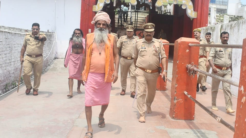 महंत सज्जन गिरी को मंदिर से बाहर निकालती पुलिस