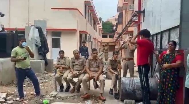 घर के बाहर बैठी पुलिस और मौजूद लोग