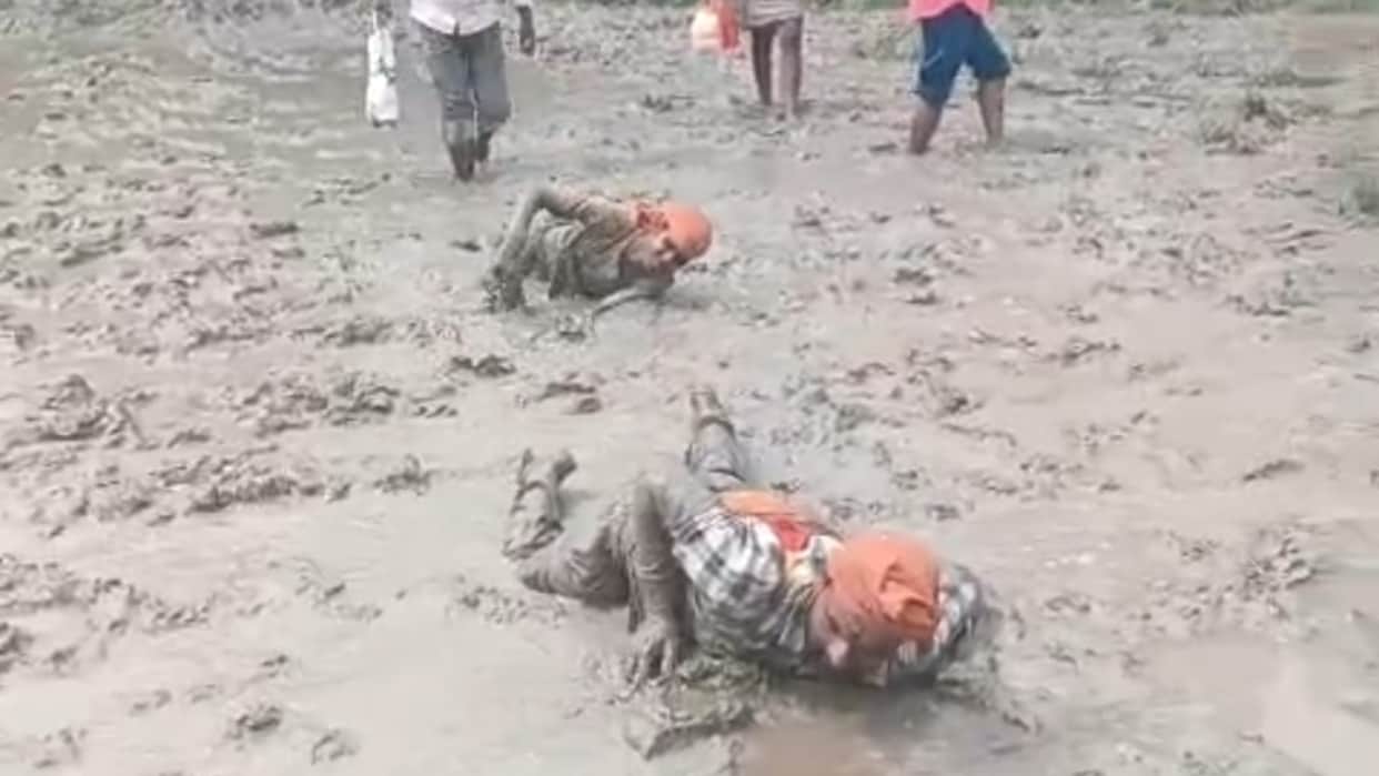 Chaos marks the path of faith Shiva devotees traverse a marshy route while performing Dandavat