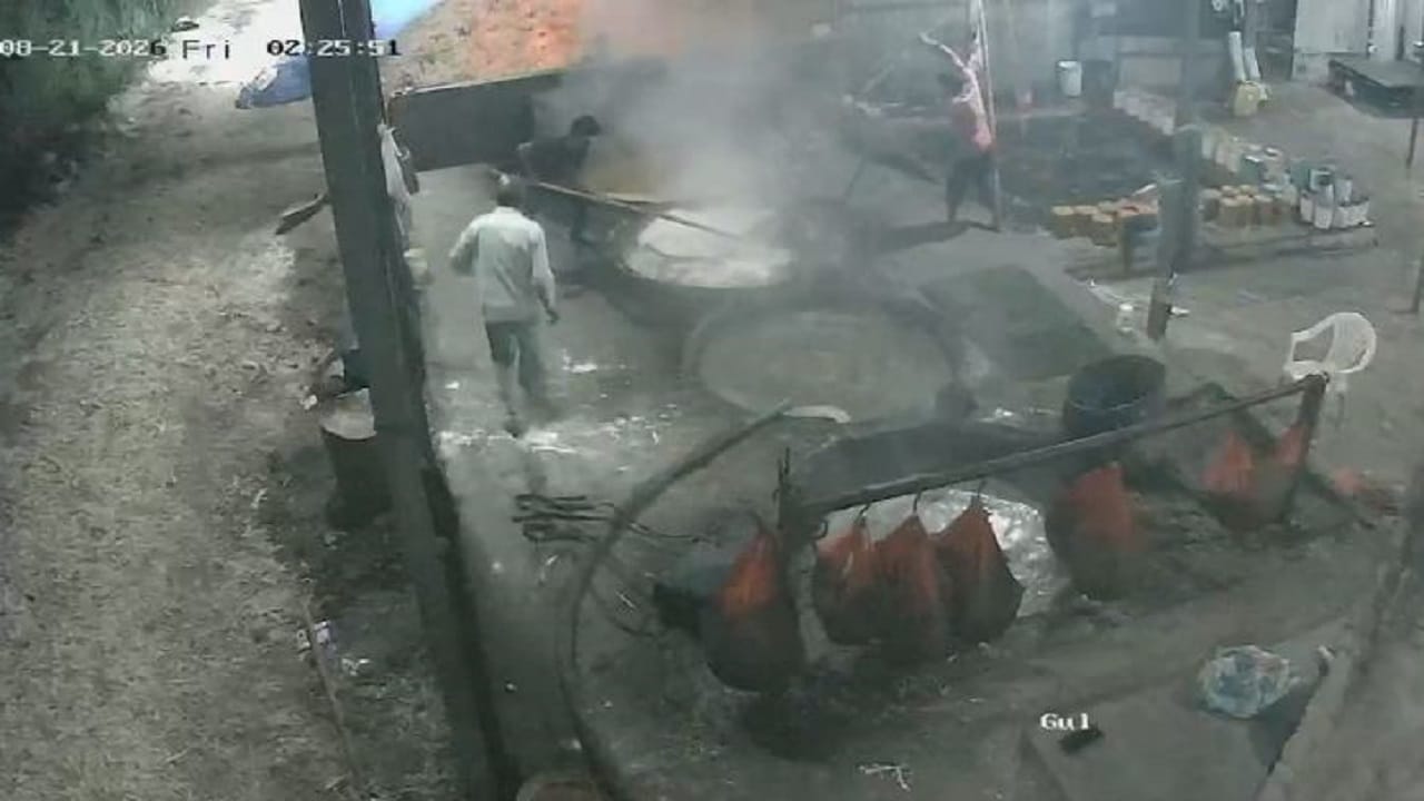 कड़ाही से युवक को बाहर निकालते साथी श्रमिक