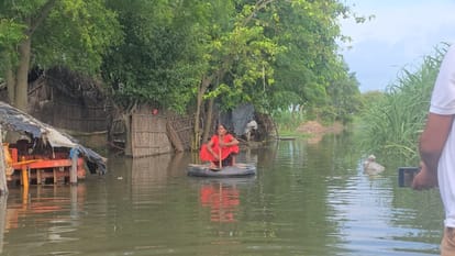 बाढ़ के बीच ट्यूब पर बैठी महिला