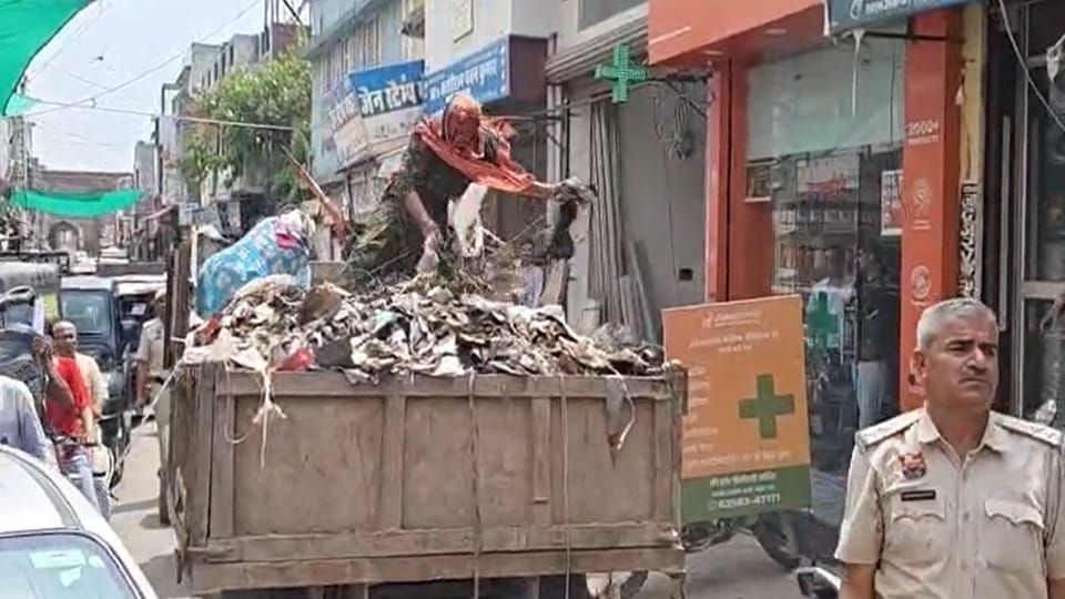 Sanitation workers in Hansi dumped garbage from a tractor onto the road.