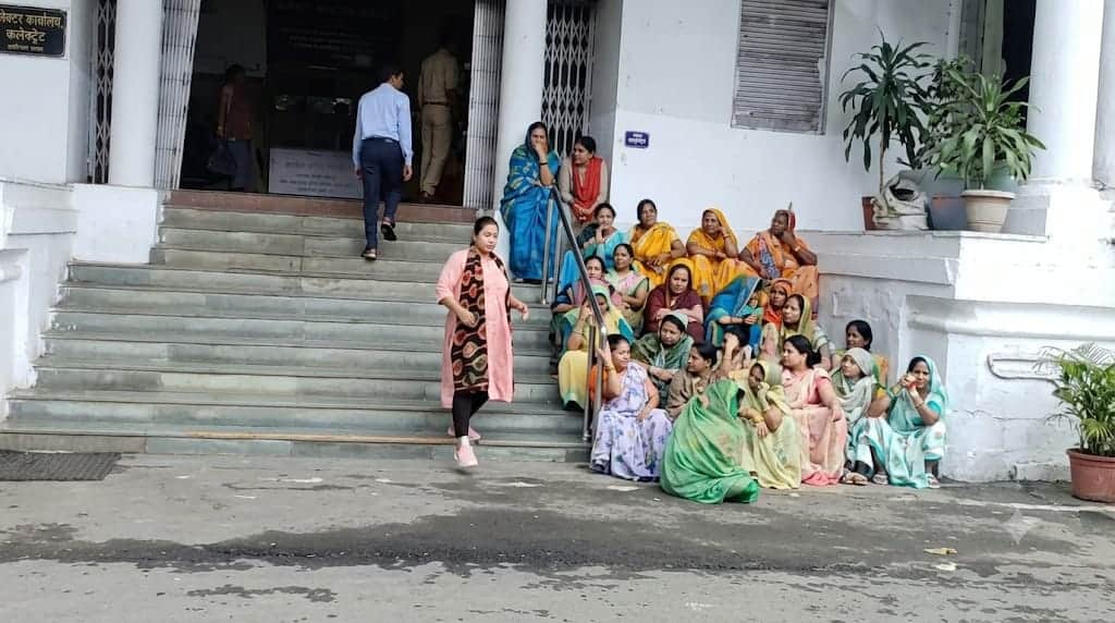 सीढ़ियों पर बैठकर प्रदर्शन करती महिलाएं