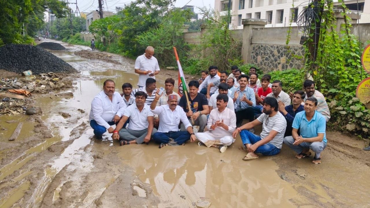 सड़क पर कीचड़ में बैठ गए कांग्रेस नेता।