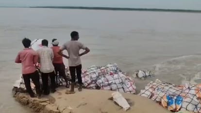 तटबंध पर खड़े ग्रामीण