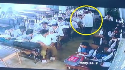 छात्र को पीटता शिक्षक।